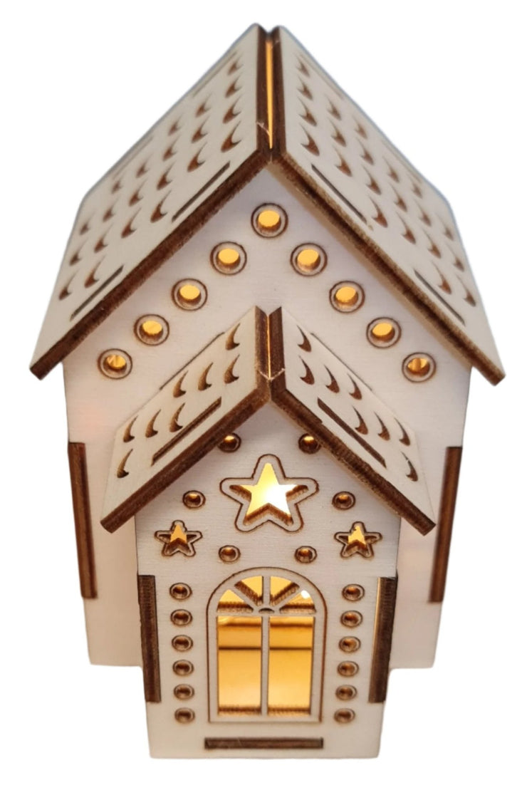 A quaint small wooden Christmas house topped with a shining star, set against a clear sky, exuding charm and warmth.