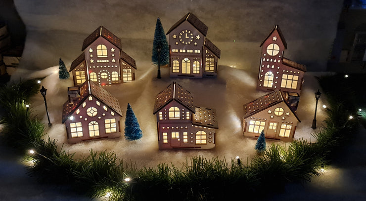 A picturesque scene of wooden Christmas houses adorned with vibrant lights, creating a festive and cheerful atmosphere.