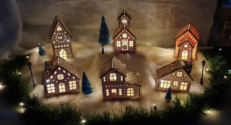 A picturesque scene of wooden Christmas houses adorned with vibrant lights, creating a festive and cheerful atmosphere.